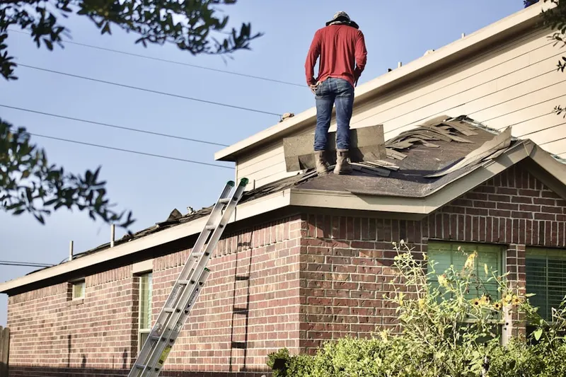 Professional roofer working on a residential roof in South Glenwood Landing